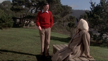 Movie still from “Same Time, Next Year” (1978), directed by Robert Mulligan – A man standing next to a woman sitting on a bench; Wide shot, Over the shoulder angle