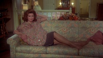 Movie still from “Same Time, Next Year” (1978), directed by Robert Mulligan – A woman sitting on a couch in a living room; Medium shot, High angle