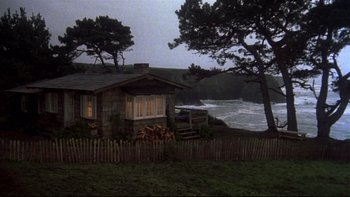 Movie still from “Same Time, Next Year” (1978), directed by Robert Mulligan – A house sitting next to a body of water at night; Extreme Wide shot, High angle