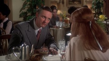 Movie still from “Same Time, Next Year” (1978), directed by Robert Mulligan – A man and woman sitting at a table with wine glasses in front of them; Medium shot, Over the shoulder angle
