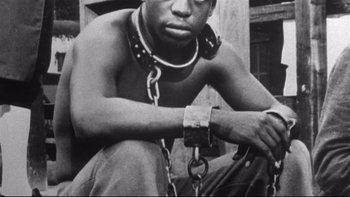 Movie still from “Same Time, Next Year” (1978), directed by Robert Mulligan – A black and white photo of a man in chains; Close Up shot, High angle