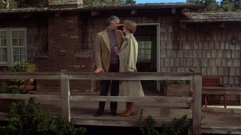 Movie still from “Same Time, Next Year” (1978), directed by Robert Mulligan – A man and a woman standing next to each other on a porch; Wide shot, Low angle