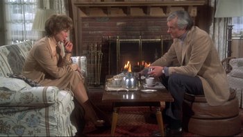 Movie still from “Same Time, Next Year” (1978), directed by Robert Mulligan – A man and a woman sitting in front of a fireplace; Medium shot, High angle