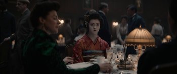 Movie still from “1899” (2022), created by Jantje Friese – A geisha sitting at a table with a cup of coffee; Medium shot, Over the shoulder angle