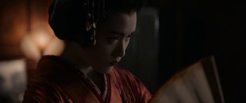 Movie still from “1899” (2022), created by Jantje Friese – A woman in a kimono looking down at a book; Close Up shot, Over the shoulder angle