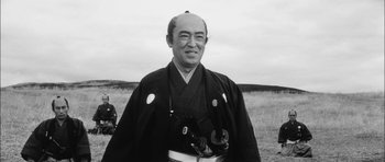Movie still from “Samurai Rebellion” (1967), directed by Masaki Kobayashi – An old photo of a man in a kimono holding a camera; Close Up shot, Low angle