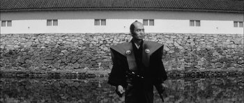 Movie still from “Samurai Rebellion” (1967), directed by Masaki Kobayashi – A man in traditional japanese garb holding a gun; Medium shot, Low angle