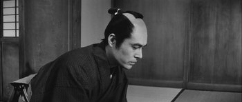 Movie still from “Samurai Rebellion” (1967), directed by Masaki Kobayashi – A black and white photo of a man with a shaved head; Close Up shot, High angle