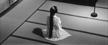Movie still from “Samurai Rebellion” (1967), directed by Masaki Kobayashi – A woman sitting on the ground wearing a white kimono; Wide shot, High angle