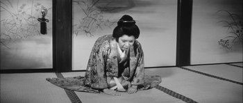 Movie still from “Samurai Rebellion” (1967), directed by Masaki Kobayashi – A woman dressed in traditional japanese clothing kneeling on the ground; Wide shot, High angle