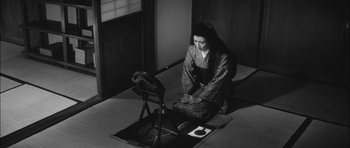 Movie still from “Samurai Rebellion” (1967), directed by Masaki Kobayashi – A woman sitting on the ground with a cat; Wide shot, High angle