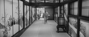 Movie still from “Samurai Rebellion” (1967), directed by Masaki Kobayashi – A man walking down a hall way wearing a kimono; Wide shot, Low angle