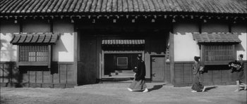 Movie still from “Samurai Rebellion” (1967), directed by Masaki Kobayashi – A person walking in front of a building; Wide shot, Low angle
