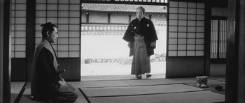 Movie still from “Samurai Rebellion” (1967), directed by Masaki Kobayashi – An older man in a kimono is standing in front of an open door; Wide shot, Low angle