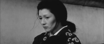 Movie still from “Samurai Rebellion” (1967), directed by Masaki Kobayashi – A woman in a black and white photo looking down at her face; Close Up shot, Low angle