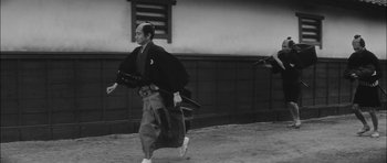 Movie still from “Samurai Rebellion” (1967), directed by Masaki Kobayashi – An old photo of a man in a samurai outfit running; Wide shot, Low angle