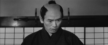 Movie still from “Samurai Rebellion” (1967), directed by Masaki Kobayashi – A black and white photo of a man with a shaved head; Close Up shot, High angle