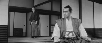 Movie still from “Samurai Rebellion” (1967), directed by Masaki Kobayashi – Two men in traditional garb are sitting on the floor; Medium shot, Low angle
