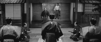 Movie still from “Samurai Rebellion” (1967), directed by Masaki Kobayashi – Two men in traditional japanese garb facing each other in front of a building; Wide shot, Over the shoulder angle