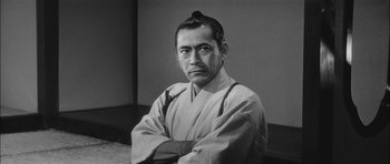 Movie still from “Samurai Rebellion” (1967), directed by Masaki Kobayashi – A man in a kimono with his arms crossed; Close Up shot, Low angle