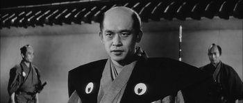 Movie still from “Samurai Rebellion” (1967), directed by Masaki Kobayashi – An old photo of a man wearing a robe with a heart on it; Close Up shot, Low angle