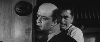 Movie still from “Samurai Rebellion” (1967), directed by Masaki Kobayashi – A man with a bald head and a man with a goatee; Medium shot, Low angle