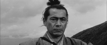 Movie still from “Samurai Rebellion” (1967), directed by Masaki Kobayashi – A man with a long black hair and a bun; Close Up shot, Low angle