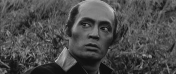 Movie still from “Samurai Rebellion” (1967), directed by Masaki Kobayashi – A black and white photo of a man with a bald head; Close Up shot, Low angle