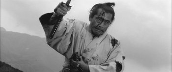 Movie still from “Samurai Rebellion” (1967), directed by Masaki Kobayashi – A man in a white robe holding a sword; Medium shot, Low angle