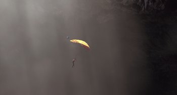 Movie still from “Sanctum” (2011), directed by Alister Grierson – A person is parachuting in the air; Extreme Wide shot, Overhead angle