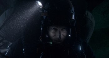 Movie still from “Sanctum” (2011), directed by Alister Grierson – A man wearing a helmet and a night vision device; Close Up shot, Overhead angle