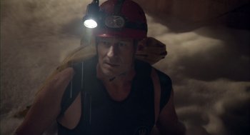 Movie still from “Sanctum” (2011), directed by Alister Grierson – A man in a hard hat with a flashlight on his head; Medium shot, Low angle