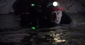 Movie still from “Sanctum” (2011), directed by Alister Grierson – A man in a red hat is in a cave; Close Up shot, High angle