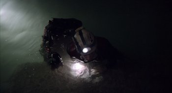 Movie still from “Sanctum” (2011), directed by Alister Grierson – A man with a helmet and a light on his head; Wide shot, Overhead angle
