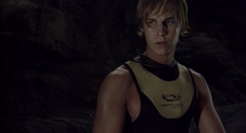 Movie still from “Sanctum” (2011), directed by Alister Grierson – A man in a wetsuit standing in front of a rock wall; Medium shot, Low angle