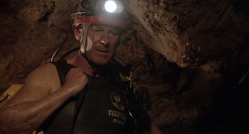 Movie still from “Sanctum” (2011), directed by Alister Grierson – A man with a helmet and a light on his head in a cave; Medium shot, Low angle