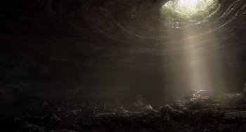 Movie still from “Sanctum” (2011), directed by Alister Grierson – Sunlight shining through a cave filled with rocks and trees; Extreme Wide shot, High angle