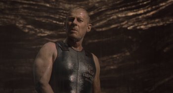 Movie still from “Sanctum” (2011), directed by Alister Grierson – A man in a body suit standing next to a cave; Medium shot, Low angle