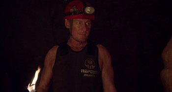 Movie still from “Sanctum” (2011), directed by Alister Grierson – A man wearing a red helmet with a light on his head; Medium shot, Over the shoulder angle