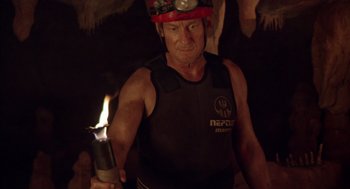 Movie still from “Sanctum” (2011), directed by Alister Grierson – A man holding a lit candle in a dark room; Medium shot, Over the shoulder angle