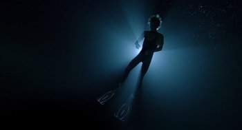 Movie still from “Sanctum” (2011), directed by Alister Grierson – A person is swimming in the dark under water; Wide shot, Overhead angle