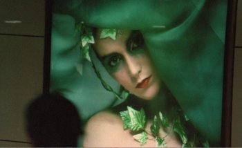 Movie still from “Sans Soleil” (1983), directed by Chris Marker – A woman with green leaves around her head; Close Up shot, High angle