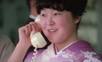 Movie still from “Sans Soleil” (1983), directed by Chris Marker – A woman in a kimono talking on a phone; Close Up shot, Low angle