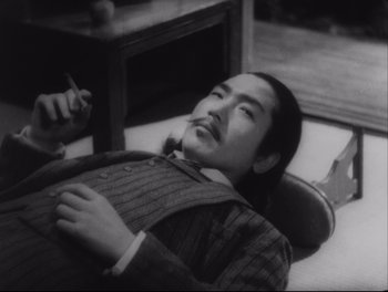 Movie still from “Sanshiro Sugata” (1943), directed by Akira Kurosawa – A man in a suit laying on the ground; Close Up shot, High angle