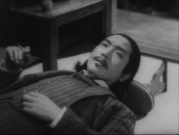 A man laying on the ground in a suit