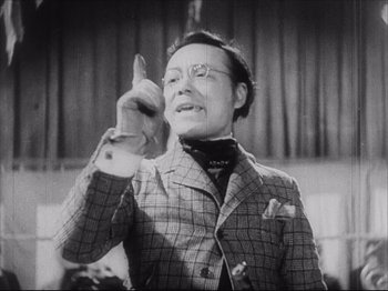 Movie still from “Sanshiro Sugata, Part Two” (1945), directed by Akira Kurosawa – An older man wearing a suit and glasses; Medium shot, Low angle