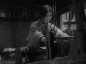A woman in a kimono working in a wood shop