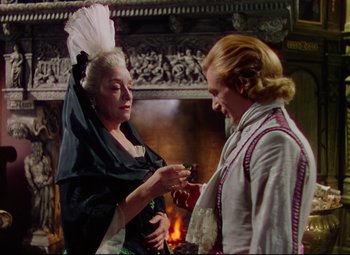 Movie still from “Saraband” (1948), directed by Basil Dearden – A man and a woman standing in front of a fireplace; Medium shot, Over the shoulder angle