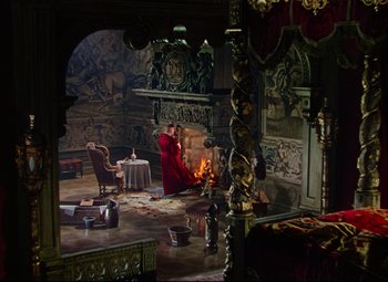 Movie still from “Saraband” (1948), directed by Basil Dearden – A man sitting in front of a fire in a living room; Wide shot, High angle