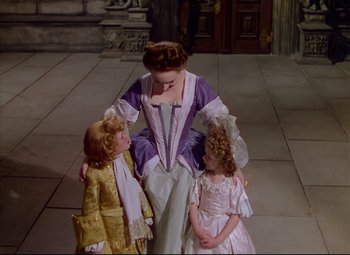 Movie still from “Saraband” (1948), directed by Basil Dearden – A woman and two children dressed in period costumes; Medium shot, High angle
